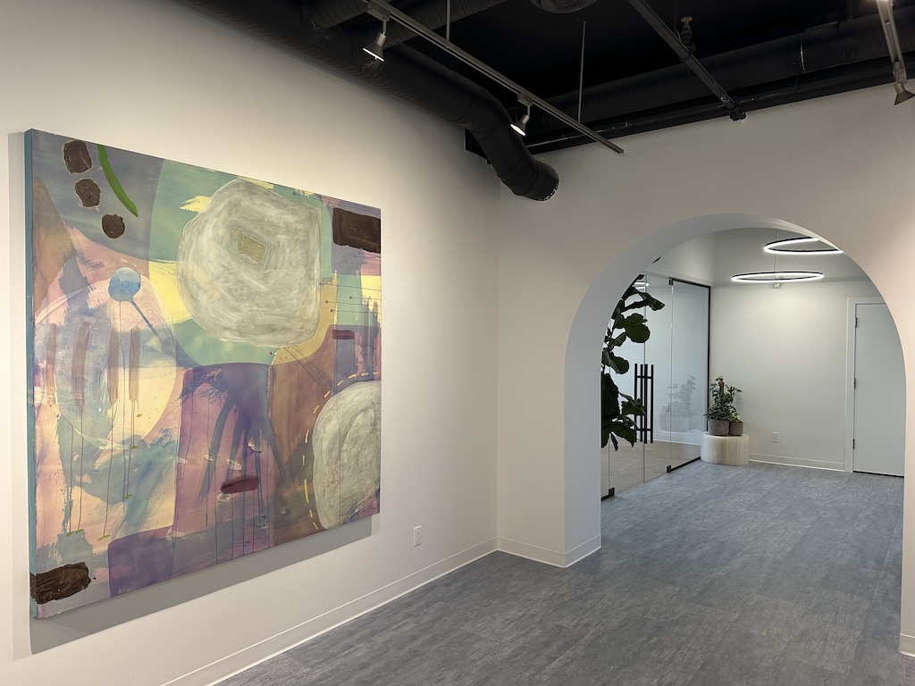 Image of Entheotech's Psychedelic-Assisted Therapy Clinic abstract art on the wall, arched doorway with round lighting and plants in the corners